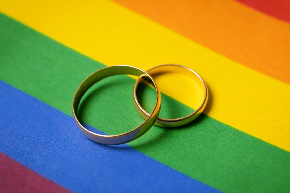Two wedding bands sit overlapped on one another on a pride flag. Opinion Columnist Habiba Kamel believes that states across the U.S. should protect the right of marriage between same-sex couples. (Getty Images