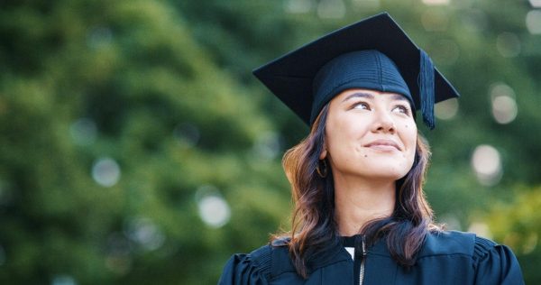 A person in a graduation cap and gown stands outside looking off into the distance. Assistant Opinion Editor Emily Beebe believes there shouldn't be age limits on notable milestones you may face in life. (Getty Images)