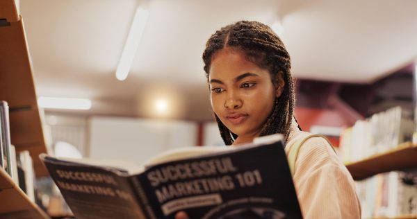 A female student reads a book in the library. Reading often can help improve your literacy as time goes on. (Getty Images) 