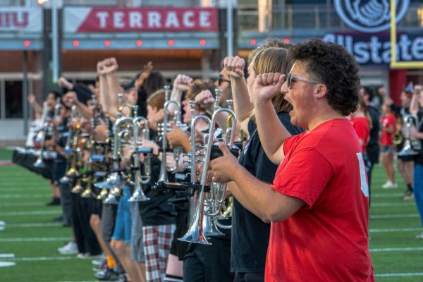 The Huskie Marching Band trumpets yell and spell “NIU” at the end of “Fight Song” during their practice on Thursday in the Huskie Stadium. The “Pride of the Midwest” will be joined by high school marching bands on Saturday during the football game against San Diego State University. (Totus Tuus Keely | Northern Star)