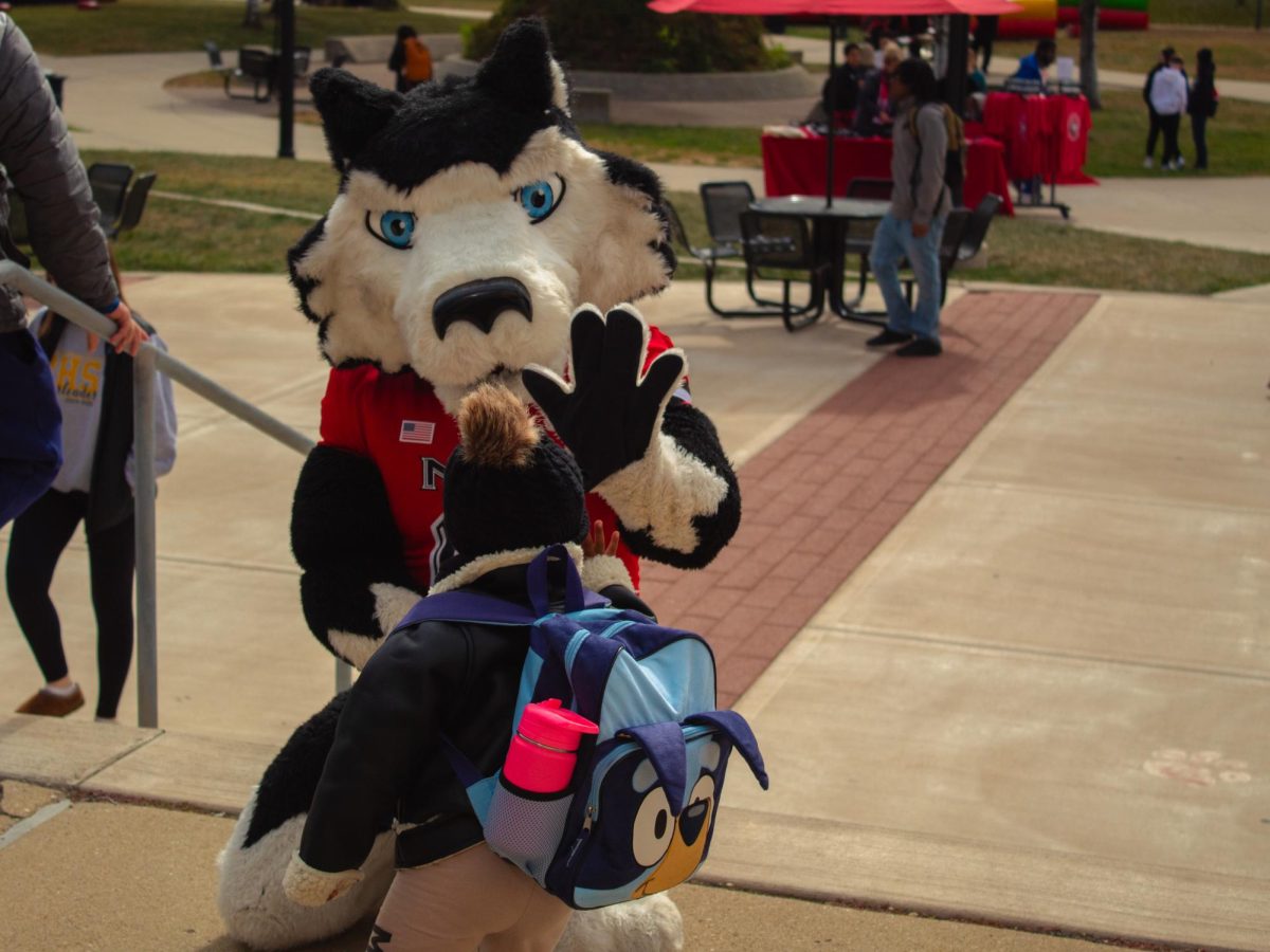 Raylin York, daughter of Chicago resident Lynnda York, high fives Victor E. Huskie at the Homecoming Kickoff Event on Oct. 14, 2024, outside of the Holmes Student Center. Students, alumni and DeKalb residents will be able to meet NIU’s mascots at the fifth annual Brunch with Mission and Victor E. from 9 a.m. to 11 a.m. on Oct. 4 in the Altgeld Auditorium. (Northern Star File Photo)