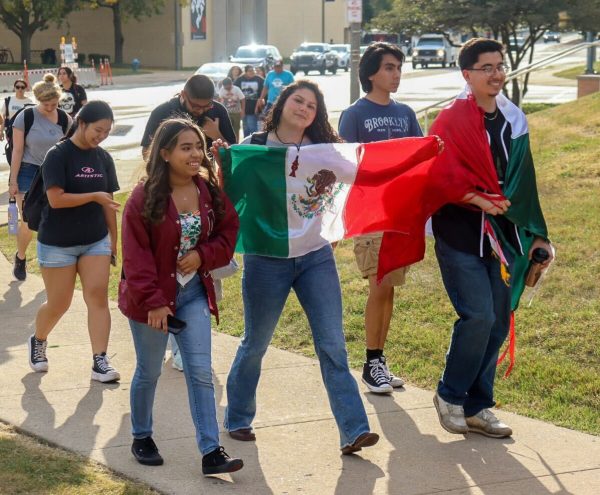 Students hold a Mexican flag as they march nearby the Holmes Student Center and the Peters Campus Life Building on Sept. 17, 2024. Opinion Columnist Santiago Montañez Bertoletti argues that more people should learn to speak Spanish. (Northern Star File Photo)