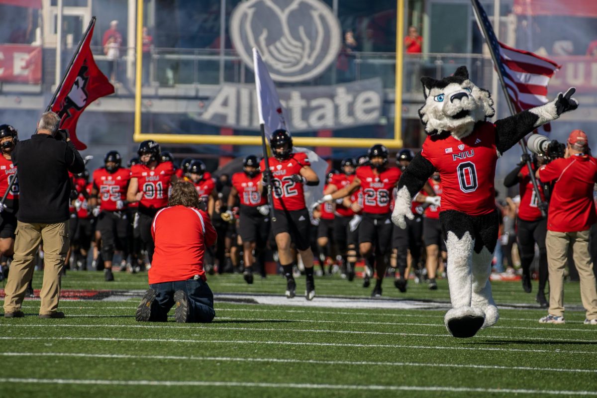 Victor E. Huskie leads the NIU football team runs onto the field before its 117th Homecoming game against the University of Toledo on Oct. 19, 2024, at Huskie Stadium in DeKalb. The Huskies are 75-32-10 all-time in their Homecoming games. (Northern Star file photo)