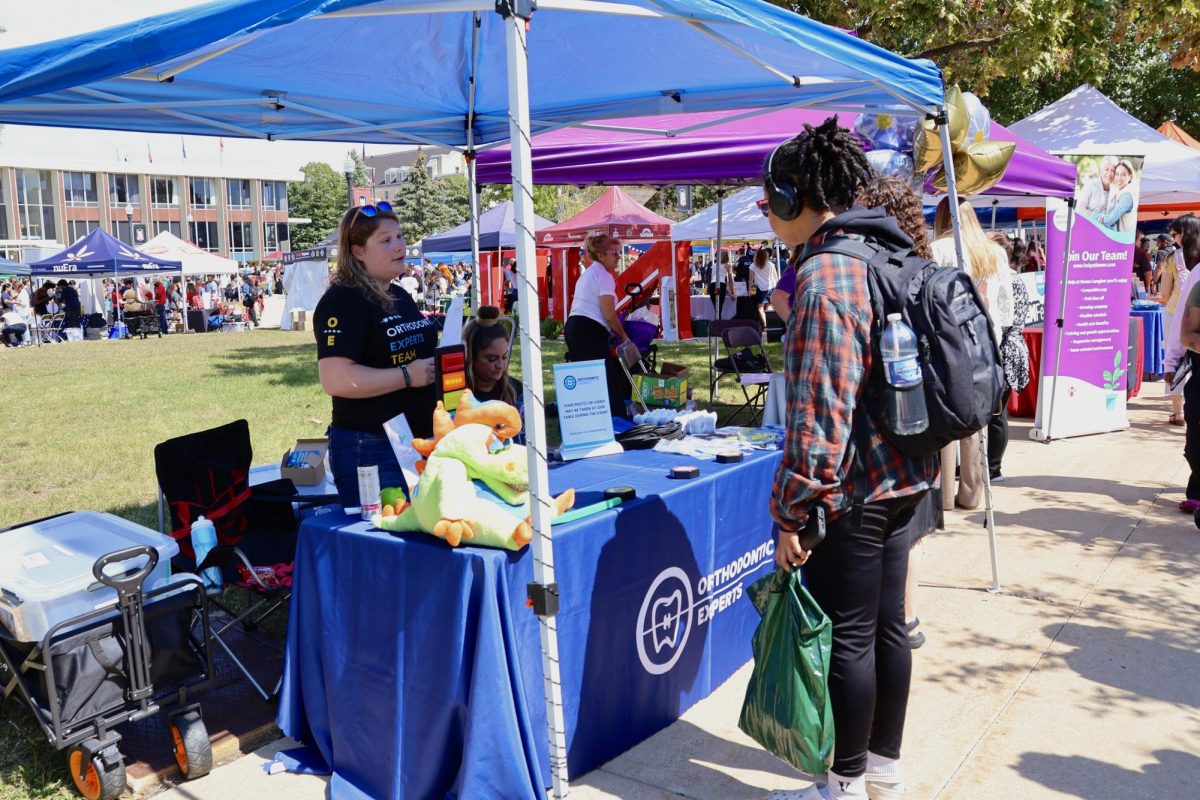 First-year psychology major Aalyiah Coleman (right) plays a trivia game at the Orthodontic Experts table with Media & Community Relations manager Shannon Bohn at the Involvement Fair. Orthodontic Experts provide braces, corrective surgeries and alignment procedures. (Sofia Howell | Northern Star)
