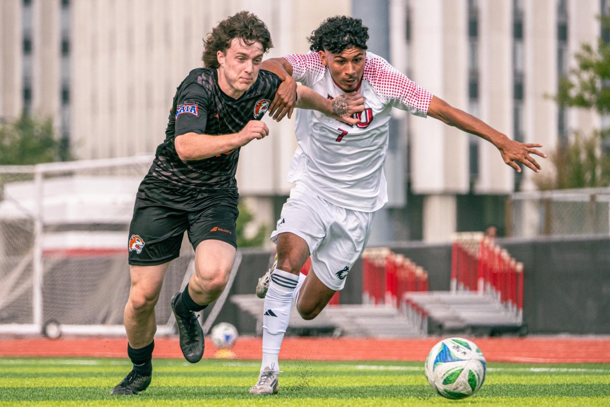 NIU men’s soccer freshman forward Tobias Crear (7) battles for the ball with Governors State University freshman defender Casidy Schlesinger (16) in the first half on Sunday at the NIU Track and Field & Soccer Complex. NIU won 4-1 against Governors State University on Sunday after their match against Chicago State University was cancelled. (Totus Tuus Keely | Northern Star)