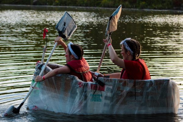 Participants of the Recycled Boat Race Kendall Wills (left) and Emmeline Sovinski paddle along the East Lagoon in their boat on Tuesday during the Recycled Boat Race. The Recycled Boat Race was held by the Campus Activities Board and challenged students to create a boat using only cardboard and other recyclable materials. (Ethan Rodriguez | Northern Star)