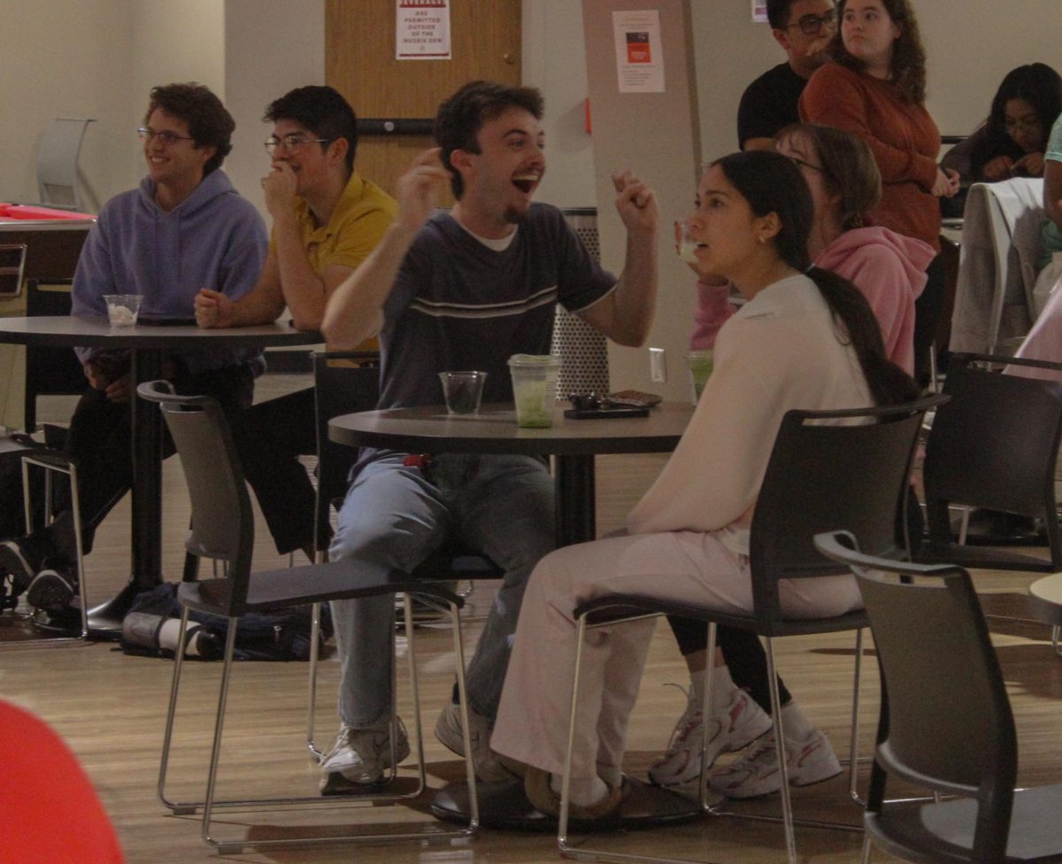 First year pre-music major Marley Kershaw cheered after successfully answering a trivia question at Trivia Night in the Huskie Den on Tuesday. Each round lasted around 10 minutes with 15 questions per round. (Alexia Beck | Northern Star)