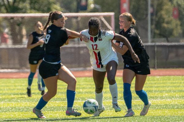 Sophomore forward Alyssa Stephenson (12) breaks past two Eastern Illinois University players on Thursday. Stephenson scored the winning goal for the Huskies at 90 minutes. (Totus Tuus Keely | Northern Star)