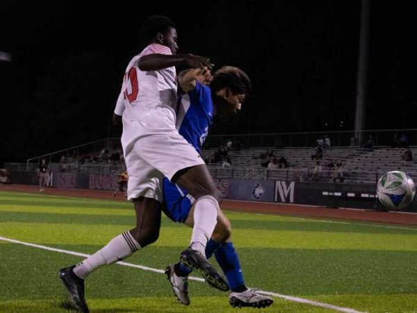 NIU men's soccer sophomore forward Katai Mukuka (40) gets boxed out by Eastern Illinois University fifth year defender Kento Tani (25) on Tuesday. The Huskies fell to the Panthers by a score of 3-2, their second straight loss. (Alexia Beck | Northern Star)