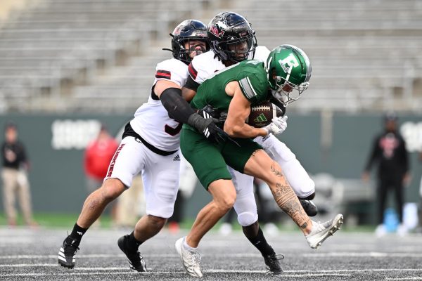 NIU redshirt senior linebacker Quinn Urwiler and senior cornerback Donte Harrison tackle Eastern Michigan University graduate student wide receiver Nick Devereaux during the third quarter of a football game on Saturday at Rynearson Stadium in Ypsilanti, Michigan. NIU earned its highest overall grade of the season from Pro Football Focus in the 16-10 loss. (Courtesy of NIU Athletics)