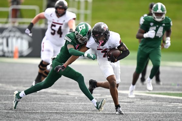 NIU sophomore wide receiver Gary Givens III (7) fends off an attempted tackle by Eastern Michigan University redshirt sophomore defensive back Caleb Dobbs during the fourth quarter of a football game on Saturday at Rynearson Stadium in Ypsilanti, Michigan. After a 16-10 loss to EMU, NIU will face the Ohio University Bobcats on Saturday in Athens, Ohio. (Courtesy of NIU Athletics)
