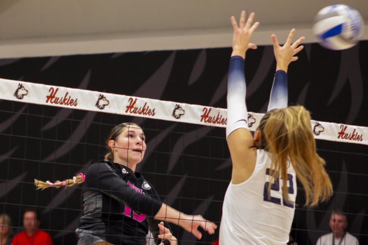NIU volleyball junior middle blocker Autumn Flynn (15) sends the ball past the hands of University of Toledo redshirt sophomore middle blocker Sierra Pertzborn (22) during a match on Oct. 17. The Huskies dropped their sixth straight match on Saturday, falling 3-1 to the University of Akron. (Ethan Rodriguez  | Northern Star)
