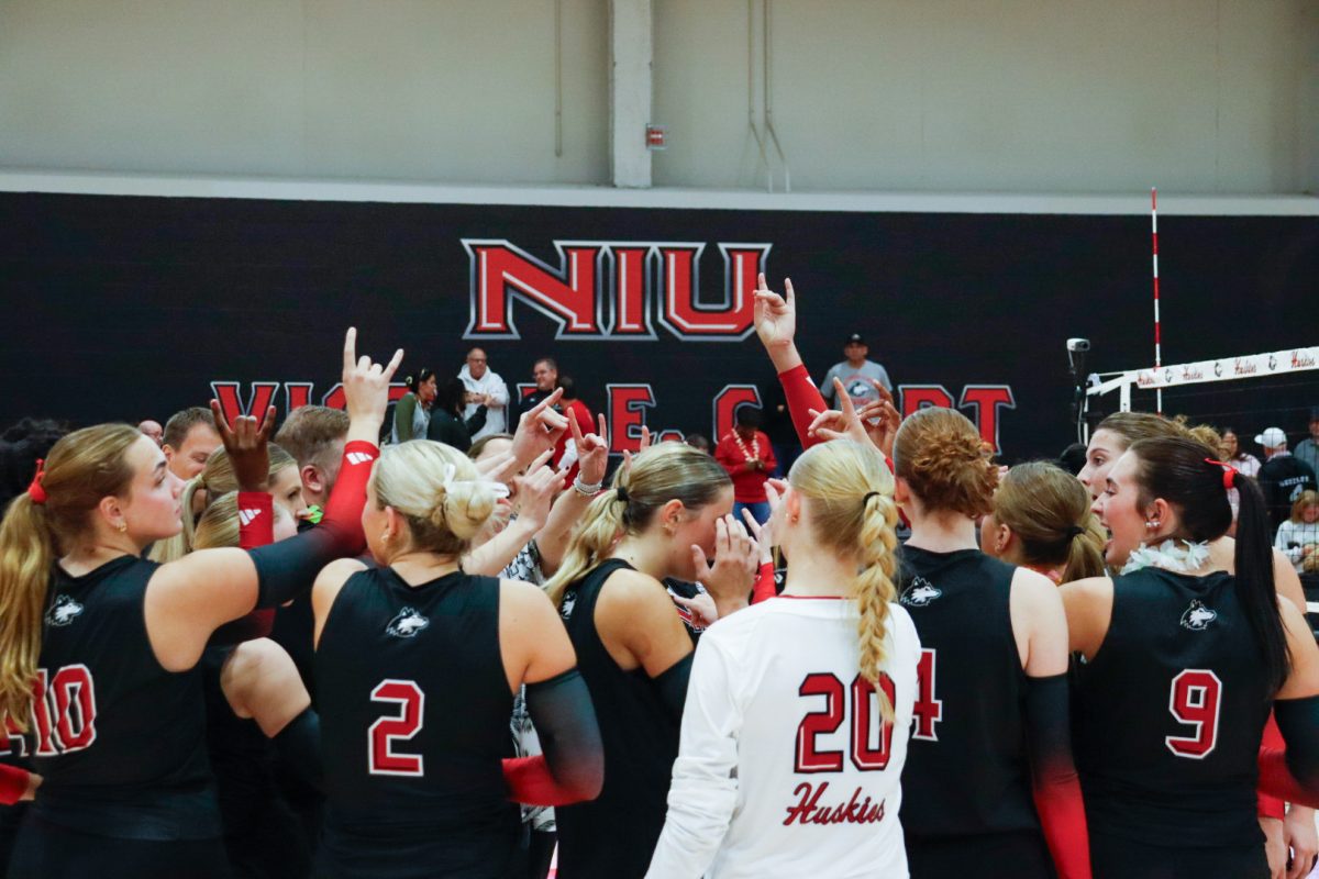 The NIU volleyball team gathers in a group huddle to discuss their performance after the Huskies’ match against Western Michigan University on Tuesday. The Huskies scored 25 and Western Michigan University 22 during the second half, scoring NIU the winning point. (Marco Alvarez | Northern Star)