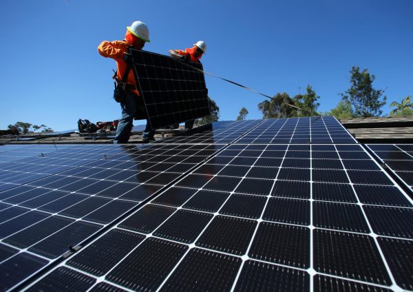 Solar installers place solar panels on the roof of a residential home in Scripps Ranch, San Diego, California. Opinion Columnist Byrdie Seda argues the DeKalb City Council shouldn't have voted against building a solar farm on Peace Road in DeKalb. (REUTERS | Mike Blake) 