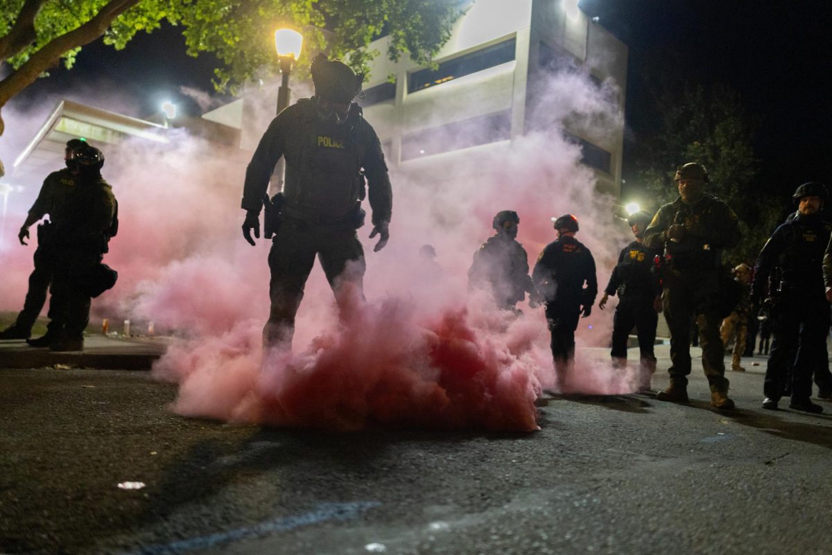 Law enforcement officers deploy smoke grenades Sunday outside of the U.S. Immigration and Customs Enforcement headquarters in an attempt to disperse protesters. Opinion Columnist Gabe Santos argues political violence doesn't solve anything. (Reuters | Carlos Barria)