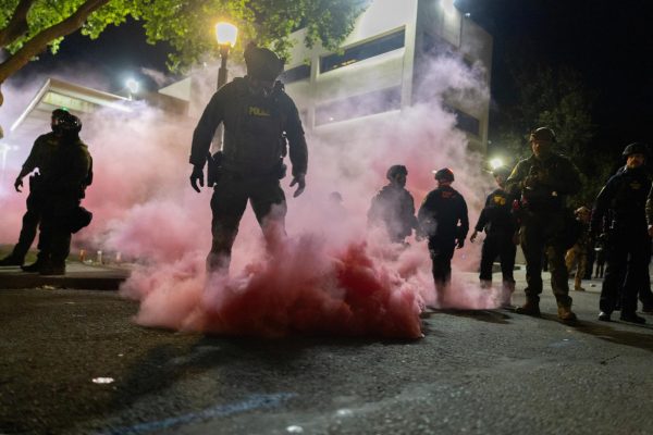 Law enforcement officers deploy smoke grenades Sunday outside of the U.S. Immigration and Customs Enforcement headquarters in an attempt to disperse protesters. Opinion Columnist Gabe Santos argues political violence doesn't solve anything. (Reuters | Carlos Barria)