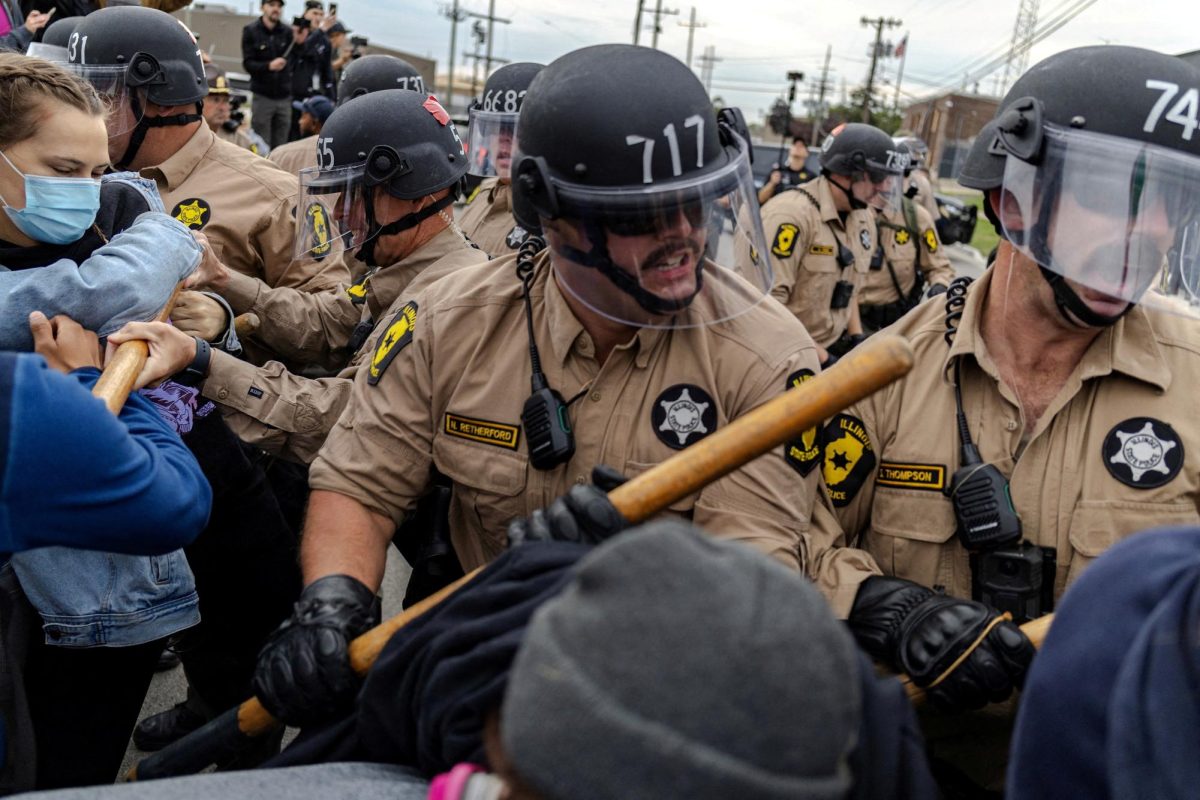 Members of the Illinois State police clash with protesters outside of the Broadview ICE facility, after U.S. President Donald Trump ordered increased federal law enforcement presence to assist in crime prevention, in Chicago, Illinois. Opinion Columnist Ethan Ernst argues that Law Officers should be identifiable and should not wear masks. (REUTERS | Jim Vondruska)