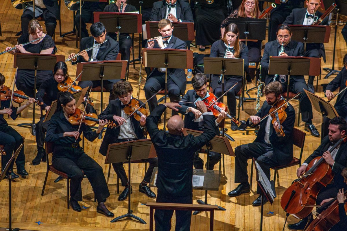 Conductor Silas Huff, then director of orchestras, crescendos with NIU Philharmonic while conducting the climax and well-known section of “Can-Can” composed by Jacques Offenbach. The Orchestra will be preforming from 7 p.m to 9 p.m at Boutell Memorial Concert Hall, Music Building. (Northern Star File Photo) 