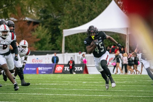 NIU sophomore running back Telly Johnson Jr. (45) rushes for a 53-yard touchdown during the first quarter of a football game on Saturday at Huskie Stadium in DeKalb. The run was Johnson's third touchdown run of 50 yards or longer this season. (Totus Tuus Keely | Northern Star)