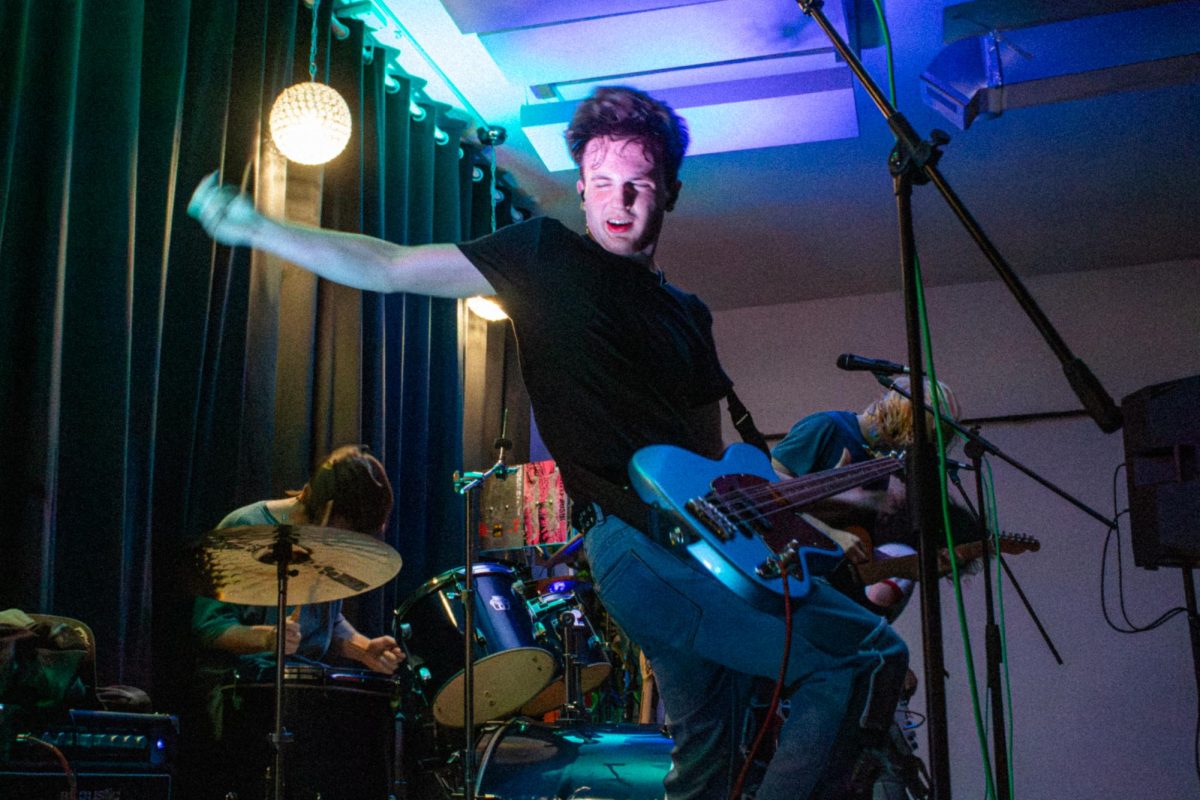 Take Care of Yourself bassist Anthony Anderson swings his arm as he plays on Saturday at the Fargo Venue, 641 E. Lincoln Highway. The band classifies their sound as a blend of emo and indie genres. (Brynn Krug | Northern Star)