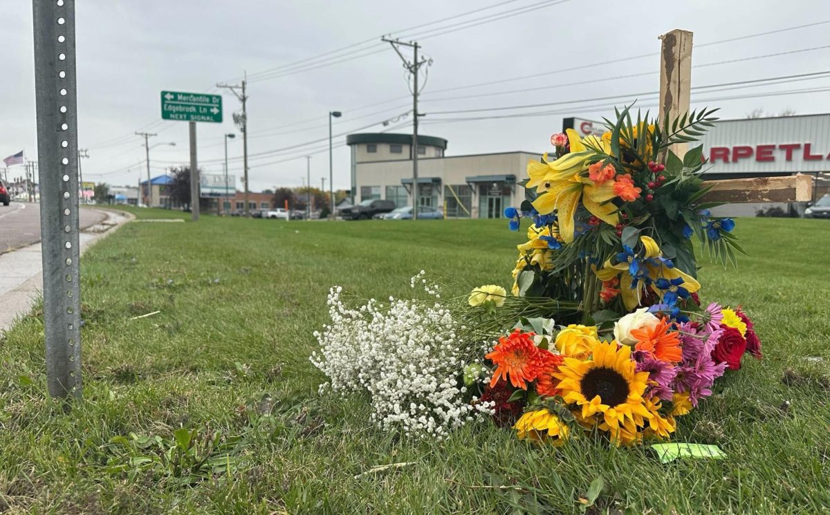 A memorial sits with fresh flowers in the grass along the 1700 block of DeKalb Avenue in Sycamore. Authorities were called to the 1700 block of DeKalb Avenue in Sycamore on Sunday after an SUV and a Suzuki motorcycle collided, killing 21-year-old NIU student Turki Alazemi. (Diego Martinez | Northern Star)
