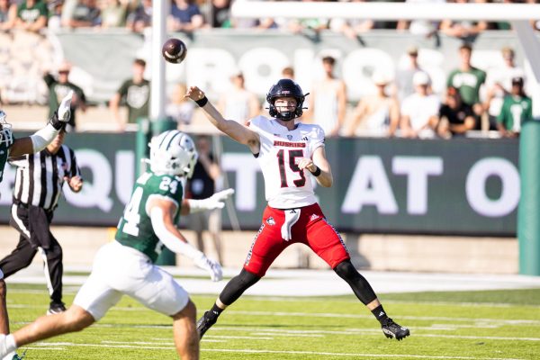 NIU redshirt sophomore quarterback Josh Holst (15) throws a pass over Ohio University graduate student linebacker Cameron Hollobaugh (24) during a football game Saturday at Peden Stadium in Athens, Ohio. Holst received his highest offensive grade of the season from Pro Football Focus after passing for a season-high two touchdowns in the 48-21 loss. (Jimmy Doles | NIU Athletics)