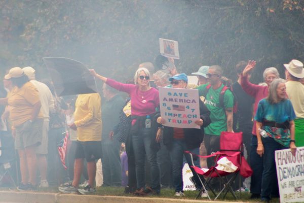 Protestors wave away smoke after a pick-up truck performed a burn out on Saturday during the No Kings 2.0 Protest at Hopkins Park. The No Kings 2.0 Protest began just before noon and lasted until around 2:30 p.m. (Ethan Rodriguez | Northern Star)