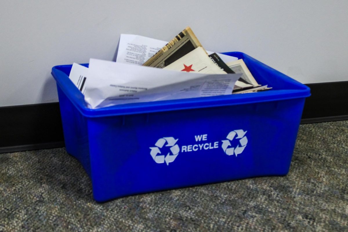 A blue recycling bin filled with paper sits on the floor. Opinion Columnist Lucy Atkinson believes that people should recycle more responsibly. (Kahlil Kambui | Northern Star)