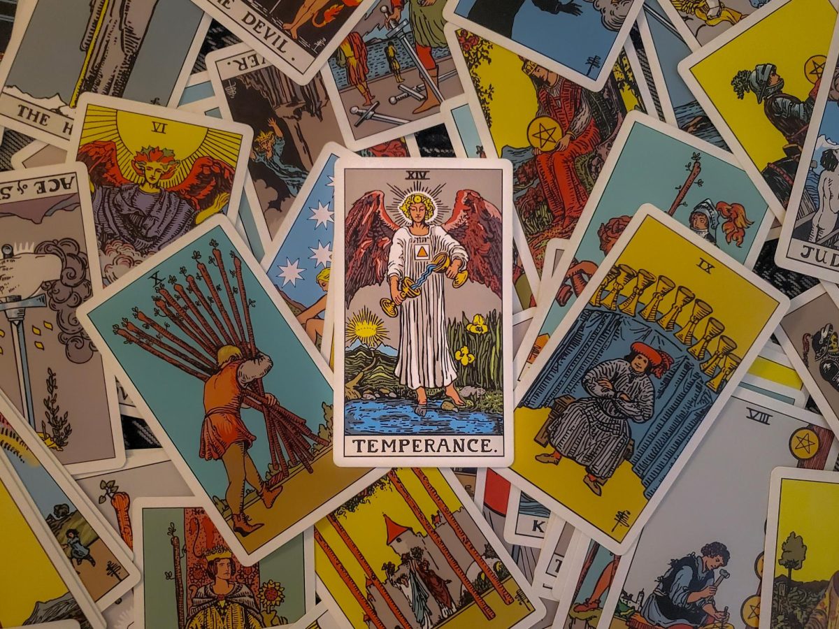 A temperance card sits atop a pile of tarot cards. Tarot originated in 15th-century Milan, Italy, as a card game called tarocchi, played by the nobility for entertainment. (Cheryl Seguin | Northern Star)