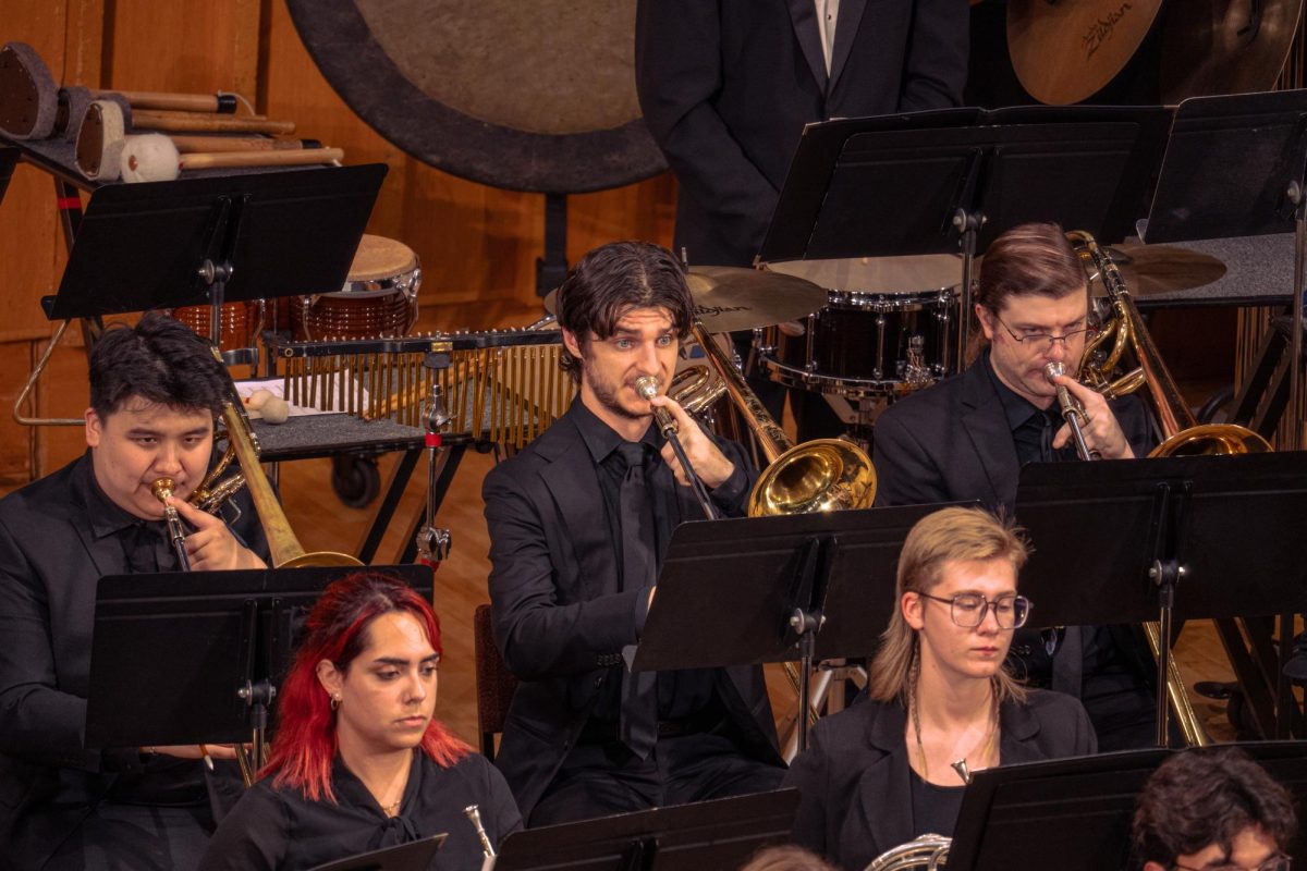 Trombonists of the NIU Wind Ensemble follow director Tom Bough’s conducting of Josh Rodriguez’s “Ballenas” on Tuesday in the Boutell Memorial Concert Hall in the Music Building. The ensemble performed six pieces, one of which was the collegiate premiere of “The Sacred Cloth” composed by Onsby Rose. (Totus Tuus Keely | Northern Star)