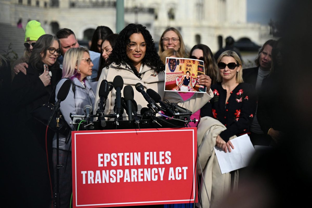 Survivor Lisa Phillips holds up her picture as she speaks during a press conference on the Epstein Files Transparency Act ahead of a House vote on the release of files related to the late convicted sex offender Jeffrey Epstein on Capitol Hill in Washington, D.C. Opinion Columnist Lucy Atkinson argues President Donald Trump's change of heart on the release of the Epstein Files is weird but doesn't change the truth. (REUTERS | Annabelle Gordon)
