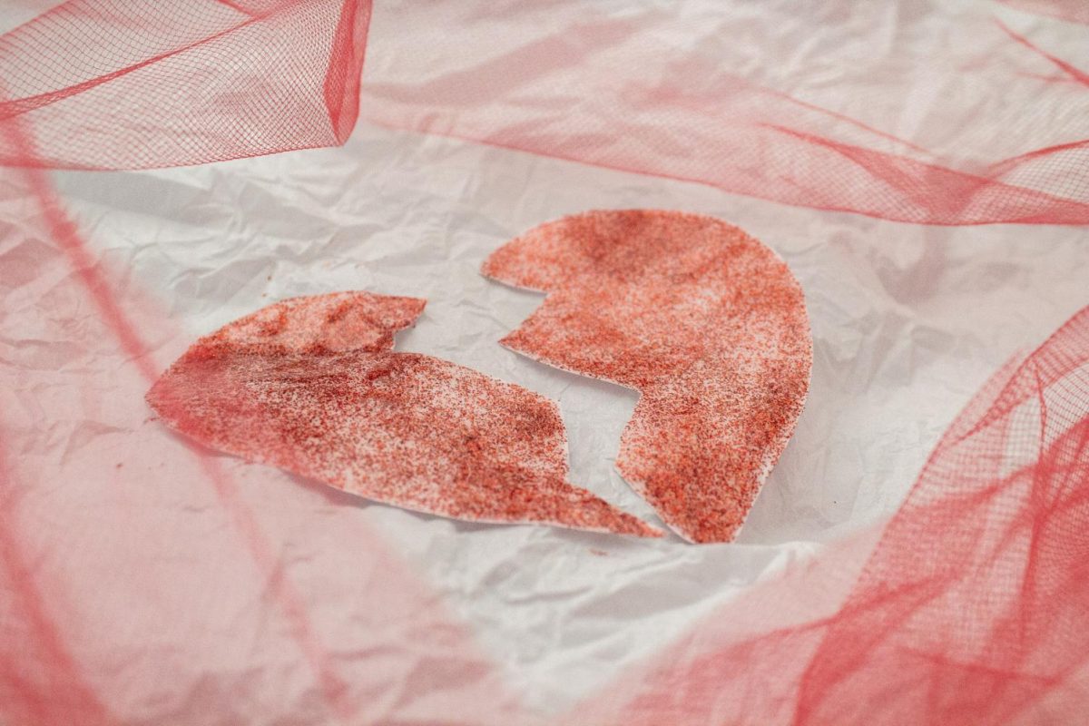 A red broken heart sits on a crumpled piece of white paper. Opinion Columnist Gabriel Santos argues that the idea that you can "fix your partner" is not healthy, and you should accept your partner's flaws and all. (Northern Star File Photo)