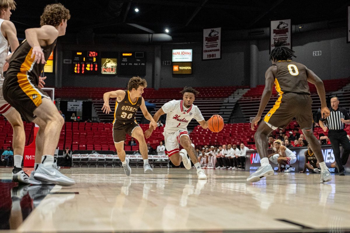NIU men’s basketball sophomore guard Makhai Valentine (1) dribbles the ball around a defender during the Huskies’ exhibition game against Quincy University on Oct. 28. The Huskies fell to Northern Iowa University in a 70-57 loss on Tuesday. (Totus Tuus Keely | Northern Star)