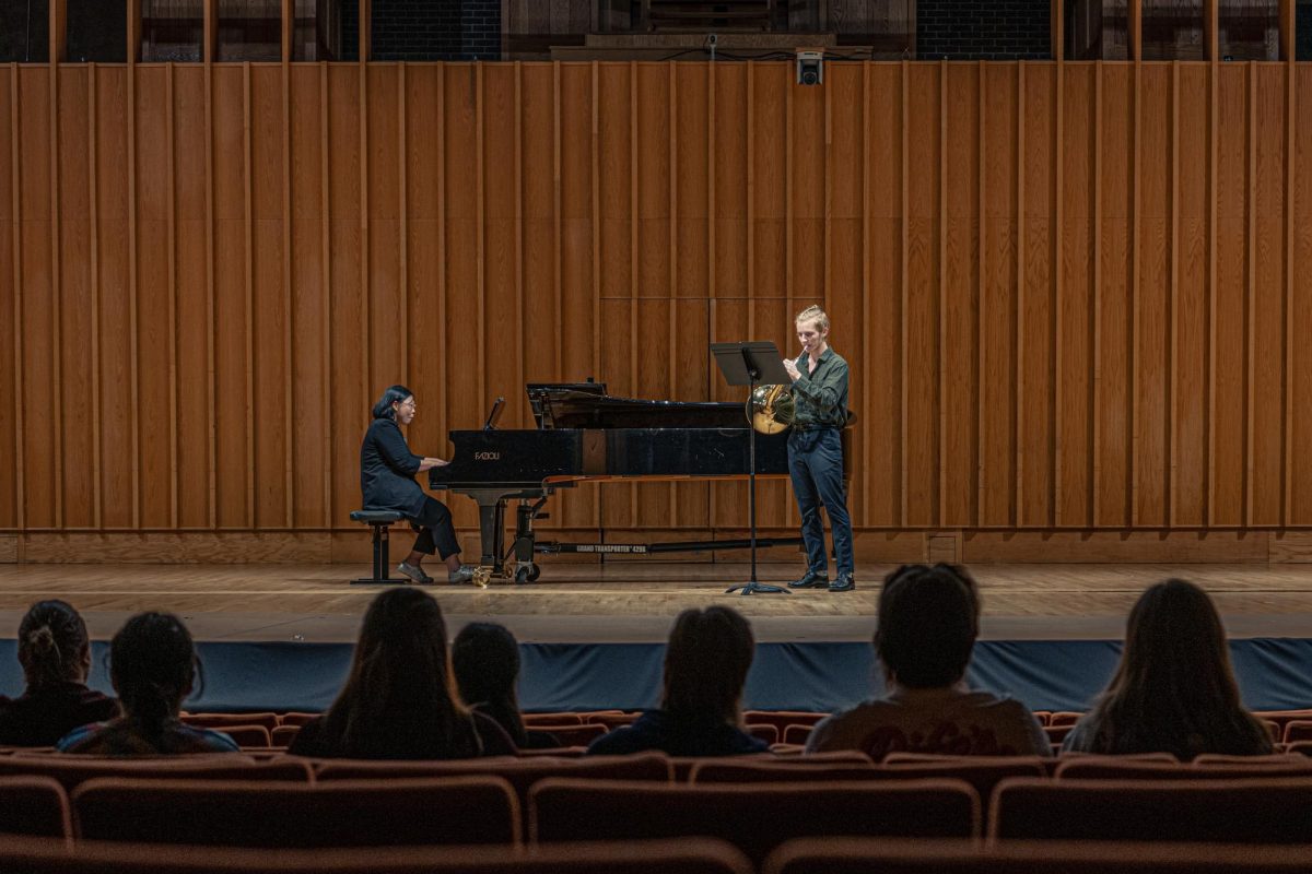 The audience watches Noah Kocsis (right) and accompanying pianist Hyounkyoung "Joy" Kim perform “Suite for horn and piano” composed by Alec Wilder on Friday in the Boutell Memorial Concert Hall in the Music Building. Noah Kocsis performed three pieces as the solo hornist during the performance. (Totus Tuus Keely | Northern Star)