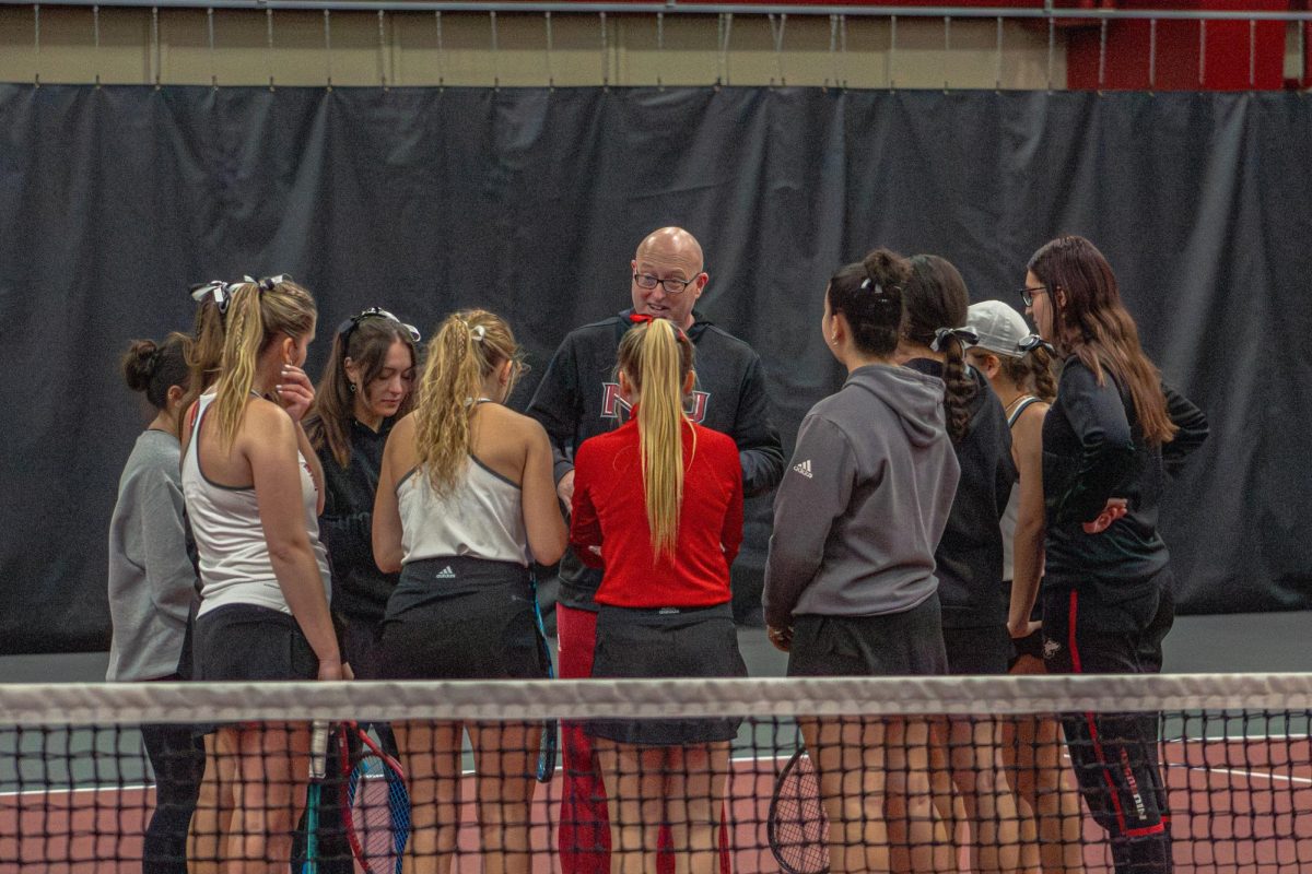 NIU women’s tennis head coach Eric Burns leads a team huddle before the Huskies’ match against Lewis University on Feb. 15. Burns announced three signings for the 2026-2027 season on Nov. 12. (Northern Star File Photo)
