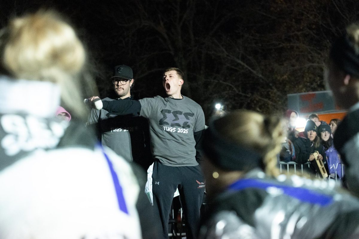 Sigma Sigma Sigma’s caller commands the tuggers to lunge back during the final rope against Alpha Phi on Wednesday. Tri Sigs was able to pull the knot into the fifth trench before APhi stepped on the rope to forfeit the match. (Totus Tuus Keely | Northern Star)