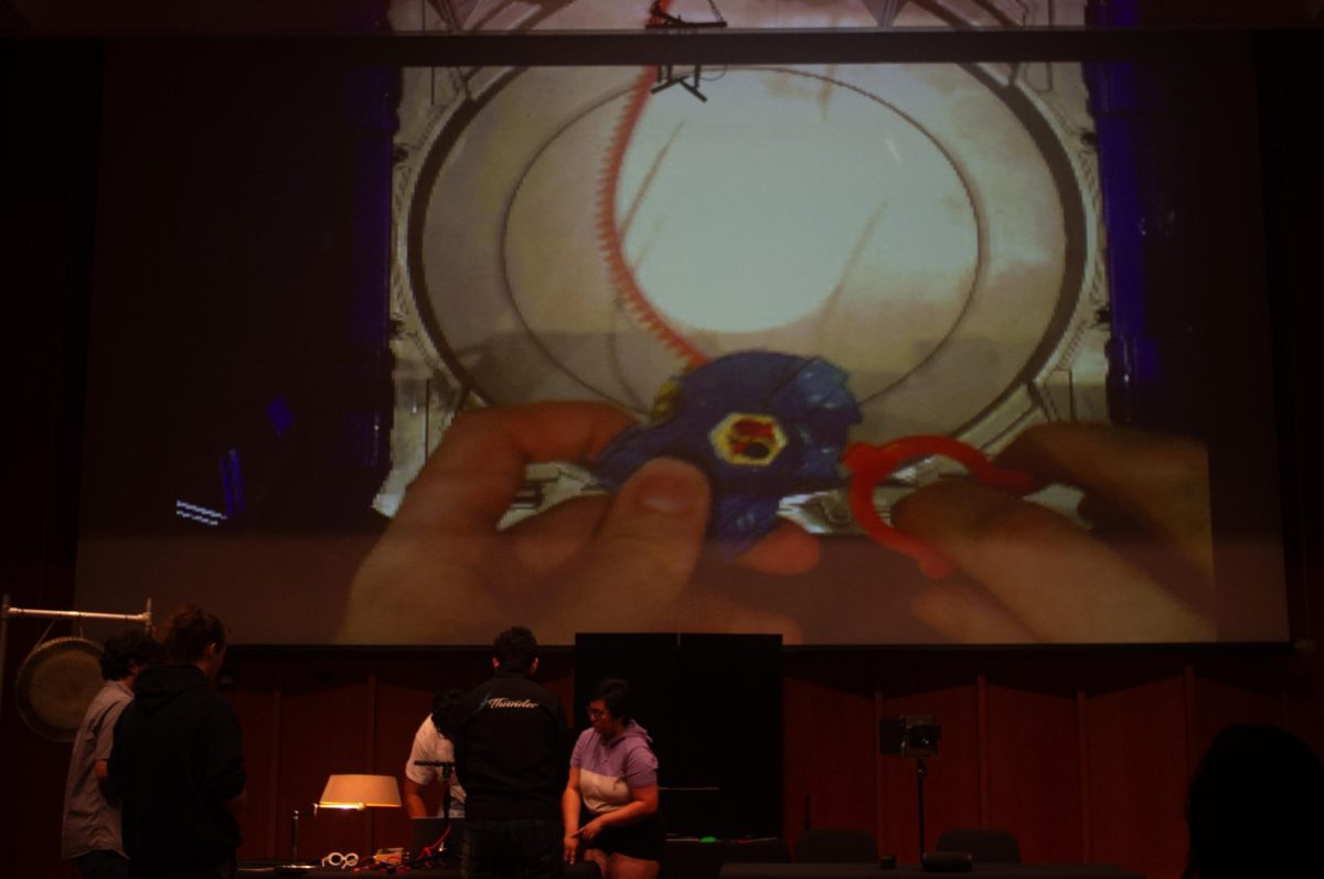 Audience volunteers play with Beyblades to trigger audio events during Zach Villegas's piece "Beyblade Madness" for the electronic computer music class's performance on May 1, 2024, in the Recital Hall of the Music Building. The Electronic and Computer Music Concert #1 will be at 7 p.m. Friday in the Recital Hall of the Music Building and will follow a different structure than the class's previous performance on May 1, 2024. (Northern Star File Photo)