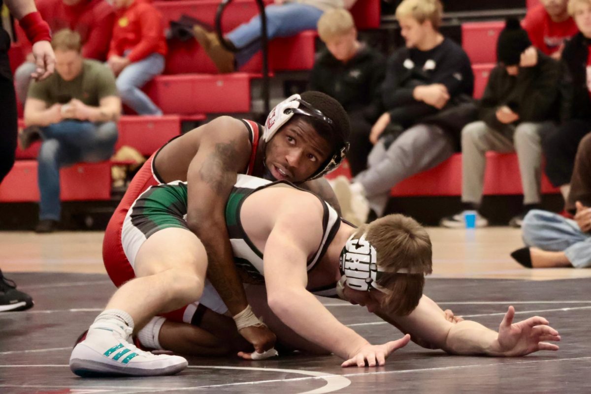NIU wrestling redshirt junior Markel Baker holds down Ohio University wrestler Ryan Meek as he eyes the clock during the 133-pound match. NIU Wrestling moved to 3-0 in MAC play with wins over Kent State University and Ohio University on Friday.  (Sofia Howell | Northern Star)