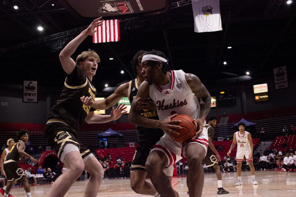 NIU men’s basketball freshman guard Taj Walters (6) drives into the paint, attempting to push through Western Michigan University players on Tuesday in the Convocation Center. NIU defeated WMU 85-65, improving to 3-6 in conference play and 7-13 overall. (Logan Reed | Northern Star)
