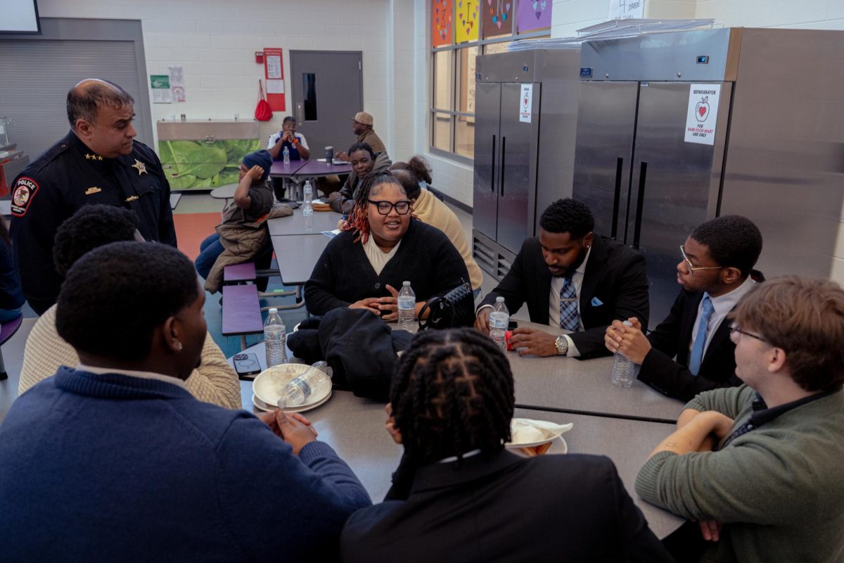 Members of Black Male Initiative, President of Liberated Minds Association Leshanti Sykes (center), DeKalb resident Brogan Long (right) and NIU Police Chief Jason John conversate about how to create a safer community on Monday at Dr. Leroy A. Mitchell Elementary School, 1240 Normal Road. Three questions were posed to each table about how to improve the local community in DeKalb. (Totus Tuus Keely | Northern Star)