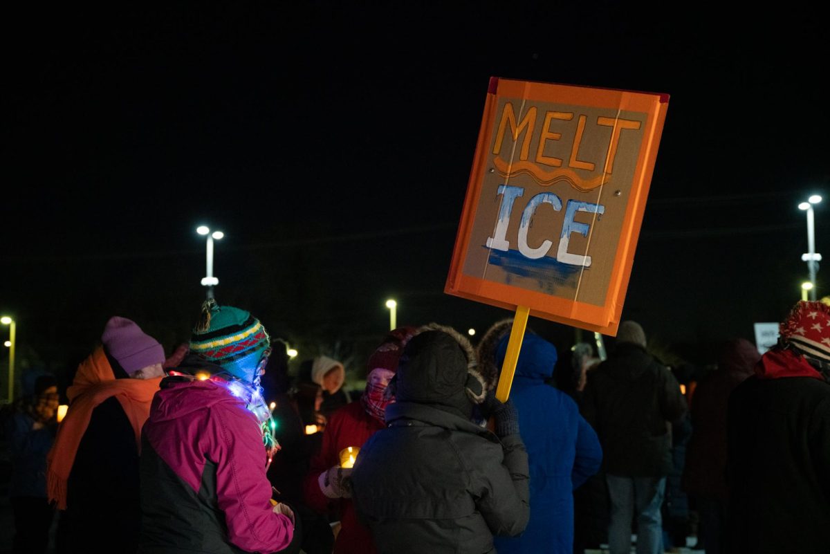 DeKalb resident Jennifer Holman holds a sign that reads, “Melt ICE” on Monday night outside the DeKalb County Administration Building, 110 E. Sycamore St., in Sycamore. The sign was two-sided, the other reading “Peace, no troops in our cities.” (Eric McGill | Northern Star)