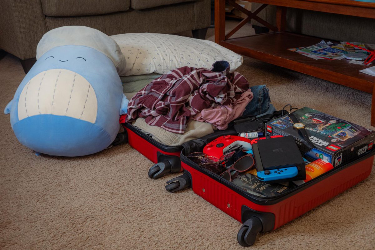 A suitcase overflows with clothes and assorted items. Opinion Editor Gabe Santos believes finding the healthy middle between packing too much and too little takes planning, but is worth it in the end to avoid stress. (Totus Tuus Keely | Northern Star)