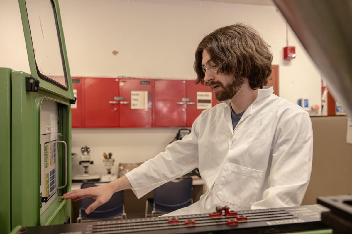 Ian Janusz, a graduate engineering technology student and a research assistant and advisor for the bioplastics lab, works on an injection molder during the bioplastics lab in Room 212 of Still Gym. The Division for Research and Innovation Partnerships held a townhall on Tuesday in Altgeld Room 301 to discuss a change in funding and to discuss a potential new model to operate. (Totus Tuus Keely | Northern Star)