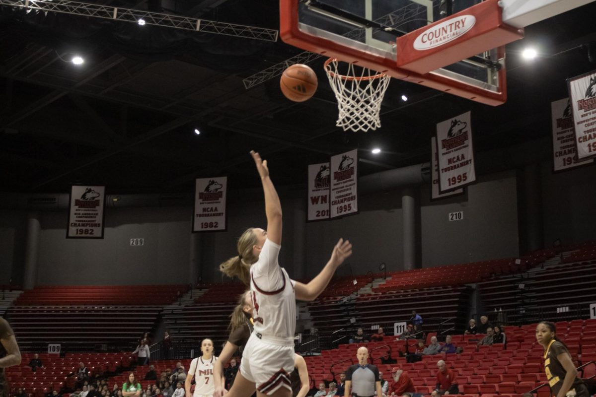 NIU women’s basketball freshman guard Emilie Sorensen (14) jumps while shooting the ball toward the hoop during the Huskies’ game against WMU on Wednesday at the Convocation Center. Sorensen led the Huskies in scoring with a total of 22 points. (Ethan Rodriguez | Northern Star)