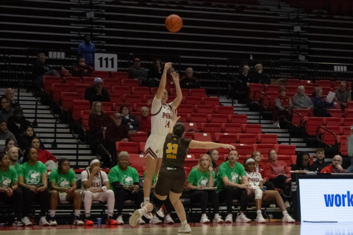 NIU freshman guard Emilie Sorensen (14) shoots from the three-point line over Western Michigan University junior guard Nile Muguira Orbe (33) during the Huskies’ game against the Broncos on Wednesday. Sorensen scored 22 points and went 3-for-4 from three in the Huskies’ 64-56 win. (Ethan Rodriguez | Northern Star)
