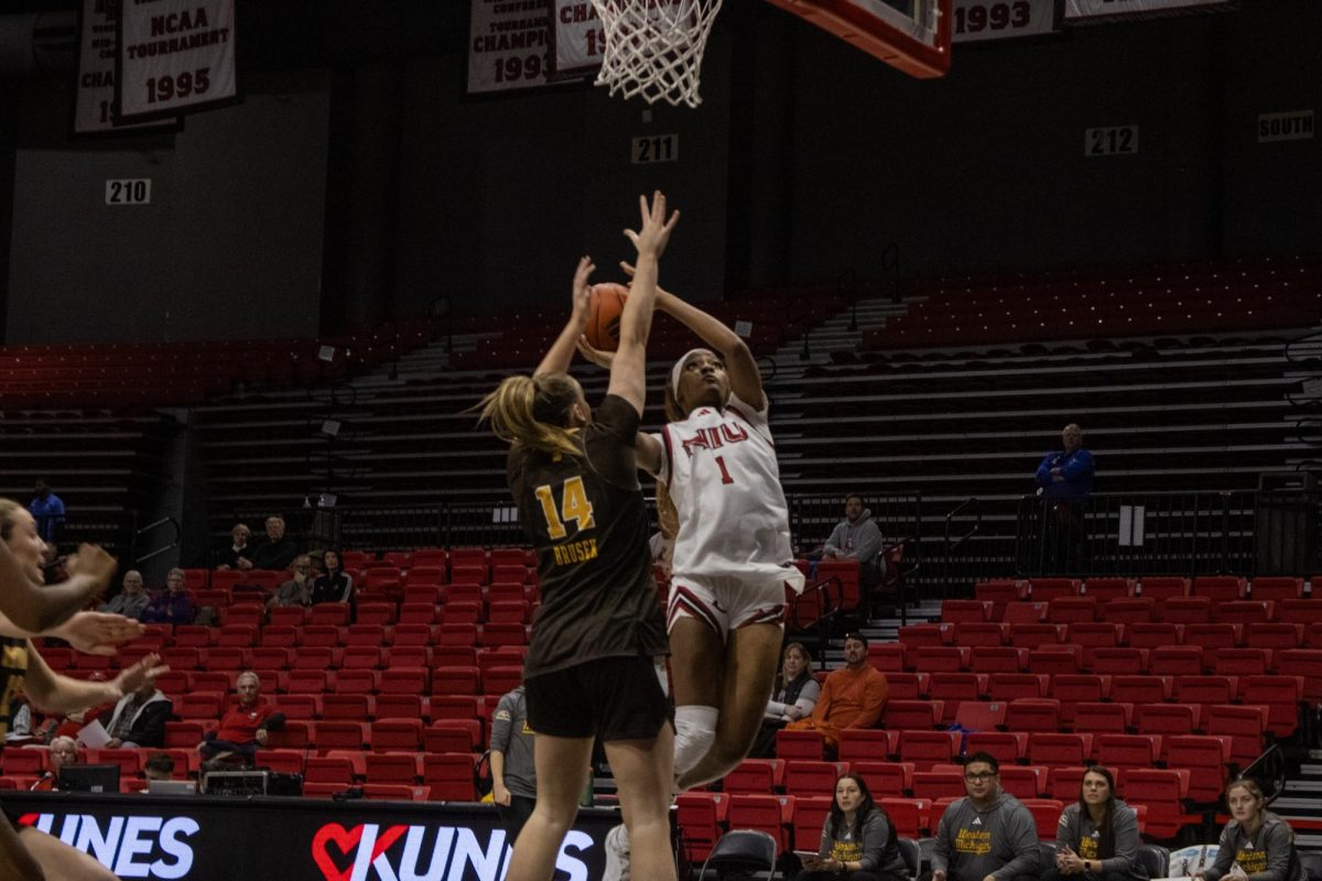NIU women’s basketball senior forward Teresa Mbemba (1) jumps past Western Michigan University senior forward Mary Clare Brusek (14) to score on Wednesday at the Convocation Center. The Huskie’s next home game is against Miami University at 11 a.m. on Wednesday at the Convocation Center. (Ethan Rodriguez | Northern Star)