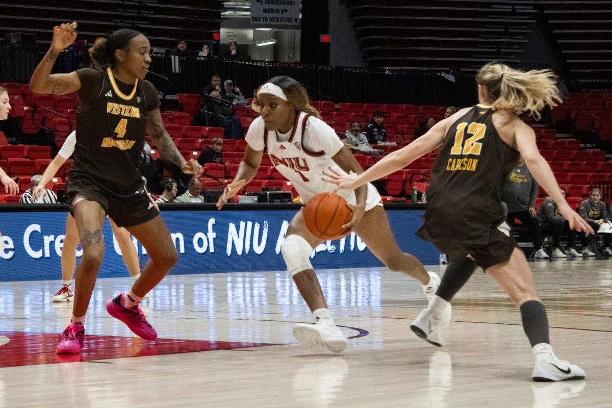 NIU women’s basketball senior forward Teresa Mbemba (1) dribbles past Western Michigan University redshirt senior forward De'Ahna Richardson (4) and senior forward Mary Clare Brusek (14) on Wednesday at the Convocation Center. Mbemba scored 9 points against WMU. (Ethan Rodriguez | Northern Star)