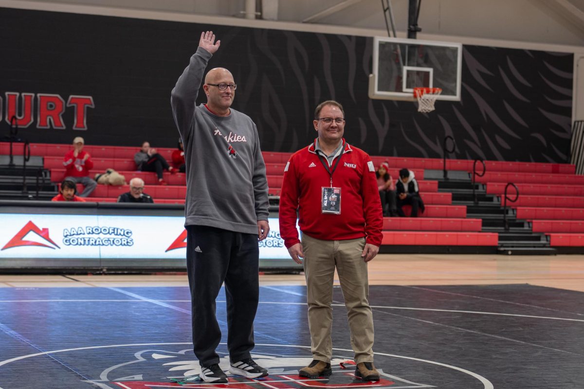 NIU women’s tennis head coach Eric Burns is recognized during Saturday’s wrestling match against Ohio University. Burns reached 400 career wins with the Huskies’ win over Marquette University on Friday. (Totus Tuus Keely | Northern Star)