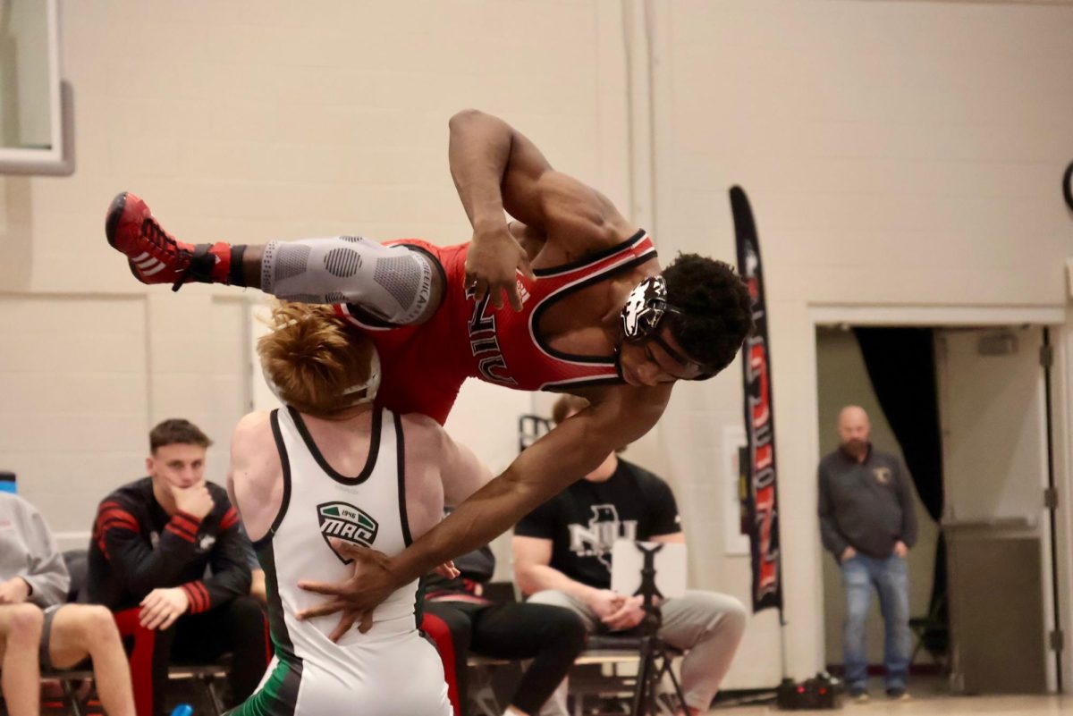 NIU wrestling redshirt freshman Charles Curtis is held in the air by Ohio University sophomore Kolten Barker during the 141-pound match on Friday in Victor E. Court in the Convocation Center. NIU defeated the Bobcats 20-17. (Sofia Howell | Northern Star)