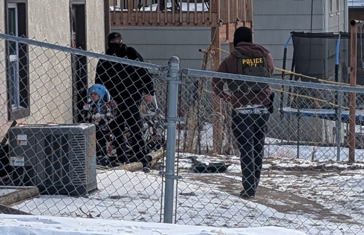 ICE agents stand next to Liam Conejo Ramos, a 5-year-old that school officials said was detained on Jan. 20 in Minneapolis. Assistant Opinion Editor Lupita Diaz believes ICE's actions in the past year have extremely harmful psychological effects on the children of immigrants. (Rachel James | REUTERS)